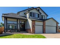 Charming two-story home featuring a well-manicured lawn, a two car garage, and a welcoming front porch at 21655 Whirlaway Ave, Parker, CO 80138