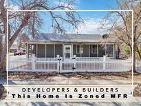 Charming home featuring a screened-in porch and a white picket fence, offering a cozy and inviting curb appeal at 6025 S Sycamore St, Littleton, CO 80120