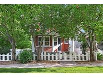 Charming home with a white picket fence and lush trees in the front yard at 2813 Central Park Blvd, Denver, CO 80238