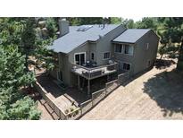 Aerial view of the home featuring a spacious deck, fenced yard and mature landscaping at 23495 Bluestem Dr, Golden, CO 80401