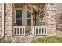 Inviting porch with a view of the exterior, accessible by a gate, and featuring stone accents at 8465 S Holland Way # 101, Littleton, CO 80128