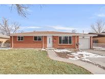 Charming brick ranch-style home with a well-maintained lawn, walkway, and single-car garage at 3212 Uvalda St, Aurora, CO 80011