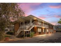 Brick apartment building featuring white iron staircases and balconies under a beautiful sky with a touch of sunset glow at 3942 E Evans Ave, Denver, CO 80210