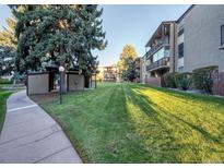 Building exterior shows large grassy area with mature trees and walkway at 2281 S Vaughn Way # 118A, Aurora, CO 80014