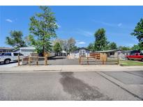 Charming single-story home with light blue siding, a spacious driveway, and attractive wooden fencing at 422 Willow Dr, Lochbuie, CO 80603