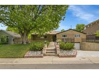 Charming brick home features a landscaped front yard with mature trees, a walkway, and an attached garage at 3444 S Bellaire St, Denver, CO 80222