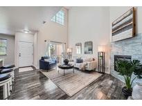 Bright living room featuring a high ceiling, modern fireplace, and stylish furnishings at 3611 S Perth Cir # 103, Aurora, CO 80013