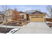 Inviting tan home with stone accents, well-kept yard, and solar panels on the roof at 25843 E Archer Dr, Aurora, CO 80018