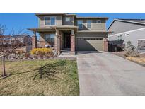 Inviting two-story home featuring a well-manicured lawn and a two-car garage, perfect for suburban living at 26909 E Cedar Ave, Aurora, CO 80018