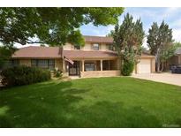 Charming two-story home with a well-manicured lawn and covered porch at 8130 E Bethany Pl, Denver, CO 80231