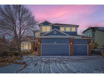 Charming two-story home with a three-car garage and a beautiful blue exterior at dusk at 2105 Keota Ln, Superior, CO 80027