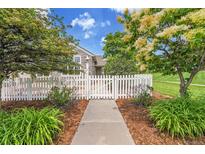 Charming home featuring a white picket fence, beautiful landscaping, and a welcoming entrance at 11268 Grove St # I, Westminster, CO 80031