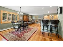Open-concept dining area featuring a rustic table, ornate rug, and bar seating adjacent to the living area at 100 River Park Dr # A, Breckenridge, CO 80424