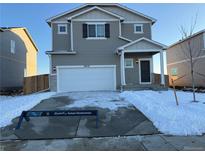 Charming two-story home featuring a two-car garage, covered porch, and neat landscaping at 48250 Shetland Dr, Bennett, CO 80102