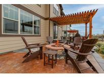 Inviting backyard patio features a cozy fire pit and pergola, perfect for outdoor relaxation and entertaining at 8827 Gore St, Arvada, CO 80007