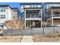 Two-story modern home with gray fence and small front patio at 9061 Delacorte St, Highlands Ranch, CO 80126