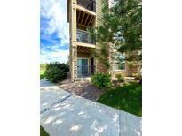 Exterior view of condo building showcasing landscaping and walkway at 17443 Nature Walk Trail # 102, Parker, CO 80134