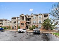 Inviting multi-story condo building featuring brick accents and outdoor balconies, surrounded by a well-maintained landscape at 12931 Ironstone Way # 303, Parker, CO 80134
