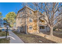 View of a three-story condo building with a mix of stone and wood siding on a sunny day at 1074 S Dearborn St # 108, Aurora, CO 80012