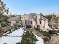 Stunning luxury home with stone accents, lush landscaping, and a beautiful outdoor living space at 18720 Lake Dr, Monument, CO 80132