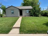 Charming single-story home featuring a well-manicured lawn and inviting entryway at 1140 S Xavier St, Denver, CO 80219