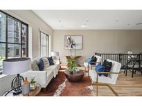 Bright living room featuring contemporary furnishings, a cowhide rug, and large windows at 3195 Blake St # 106, Denver, CO 80205