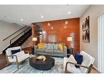 Stylish living room with sleek decor, wood accent wall, and comfortable seating arrangement at 3195 Blake St # 106, Denver, CO 80205