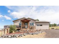 Ranch style home with stone accents, deck, and mountain views at 8408 Vinegarroon Rd, Parker, CO 80138