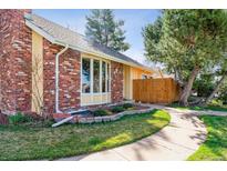 Charming brick and siding home with a well-maintained lawn and beautiful landscaping at 7641 S Rosemary Cir, Centennial, CO 80112