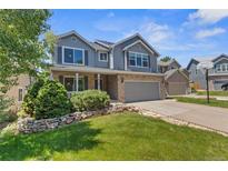 Charming two-story home with brick and siding, a well-manicured lawn, and a two-car garage at 14185 W Warren Cir, Lakewood, CO 80228