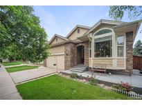 Charming home with a well-maintained front yard, brick accents, and a cozy porch bench at 6581 W Alamo Dr, Littleton, CO 80123