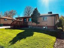 Charming brick home featuring a well-maintained lawn and a cozy wooden deck, perfect for outdoor relaxation at 3871 Moore St, Wheat Ridge, CO 80033