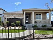 Charming single-story home featuring stone accents, a covered porch, and a well-manicured front yard at 18940 E 96Th Pl, Commerce City, CO 80022