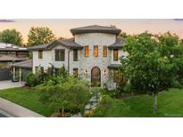 Stunning stone-clad home boasts mature trees, lush lawn, and meticulous landscaping at 5455 E Cedar Ave, Denver, CO 80246