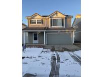 Two-story house with gray siding, attached garage, and snowy front yard at 21459 Randolph Pl, Denver, CO 80249