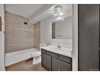 Cozy bathroom featuring a shower-tub combination, modern vanity, and neutral tile at 6930 E Girard Ave # 106, Denver, CO 80224