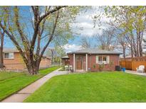 Charming brick home with a well-manicured lawn and mature trees, showcasing curb appeal at 2459 S Corona St, Denver, CO 80210