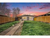 Charming home with a well-maintained front yard, walkway, and delightful sunset backdrop at 4827 Meade St, Denver, CO 80221