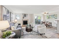 Bright living room featuring a fireplace, modern decor, and sliding door access to the outside at 7680 Depew St # 1404, Arvada, CO 80003