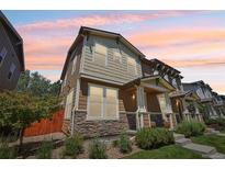 Charming two-story townhome featuring a stone-accented facade and well-maintained landscaping at 1557 S Dallas Cir, Denver, CO 80247