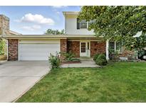 Charming brick home featuring an attached garage and a well-manicured front yard at 1341 S Blackhawk Way, Aurora, CO 80012