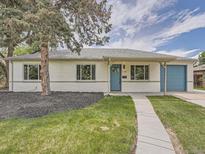 Charming single-story home featuring a blue front door, blue garage door and landscaped front yard at 1245 Troy St, Aurora, CO 80011