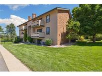 Charming condo building with well-maintained landscaping and balconies on a sunny day at 420 Zang St # 3-208, Lakewood, CO 80228