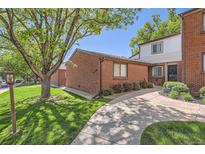 Charming brick condo with a lush, green lawn and mature trees in a tranquil community at 6330 E Wesley Ave, Denver, CO 80222