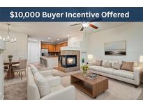 Inviting living room featuring a fireplace, ceiling fan, and open floorplan with natural light at 9907 Martin Luther King Blvd # 103, Denver, CO 80238