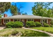 Charming single-story brick home with mature trees and a well-maintained front yard on a sunny day at 1000 Salem St, Aurora, CO 80011