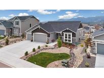 Charming gray home with a three car garage and beautifully xeriscaped front yard at 16840 New Autumn Dr, Monument, CO 80132