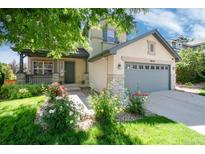 Charming home featuring a well-manicured lawn, beautiful roses, and a two car garage at 9610 S Dover Way, Littleton, CO 80127