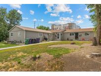 Charming single-story home with a well-maintained lawn and lush landscaping on a sunny day at 1217 Osceola St, Denver, CO 80204