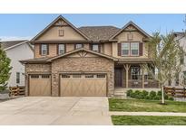 Charming two-story home with stone accents, a three-car garage, and a covered front porch at 2165 Summerlin Ln, Longmont, CO 80503